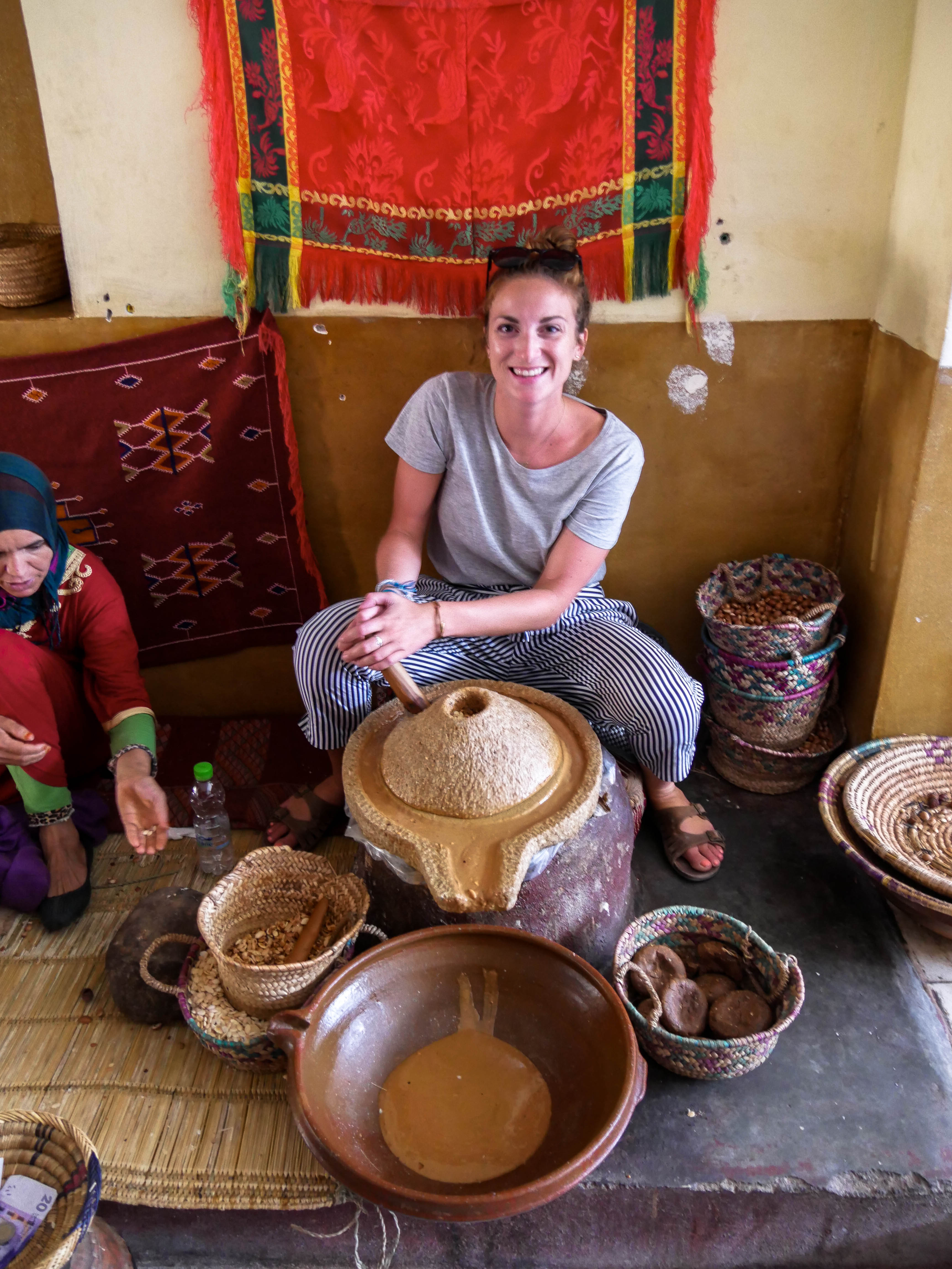 Travel girl making aragan butter in Morocco