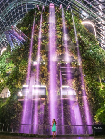 Travel girl at Cloud Forest indoor waterfall at night
