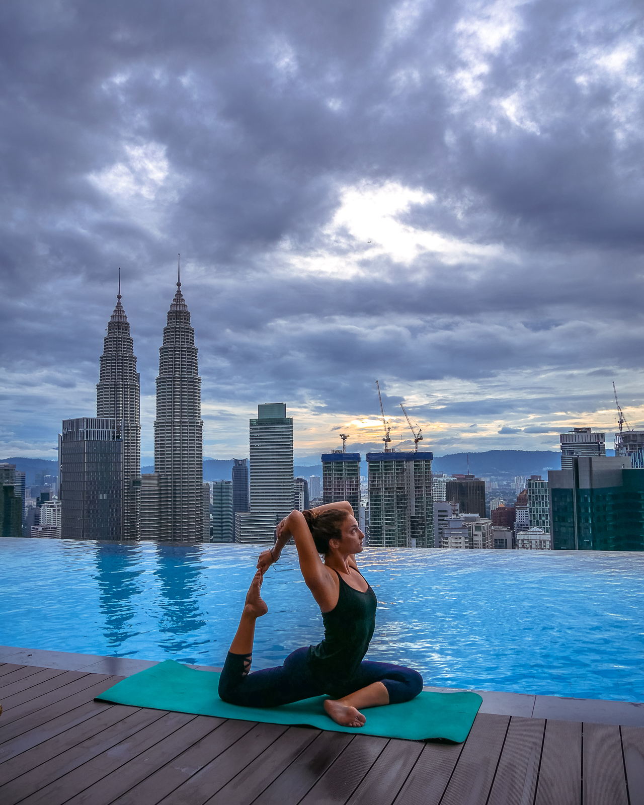 Rooftop pool sunrise in Kuala Lumpur with yoga pose