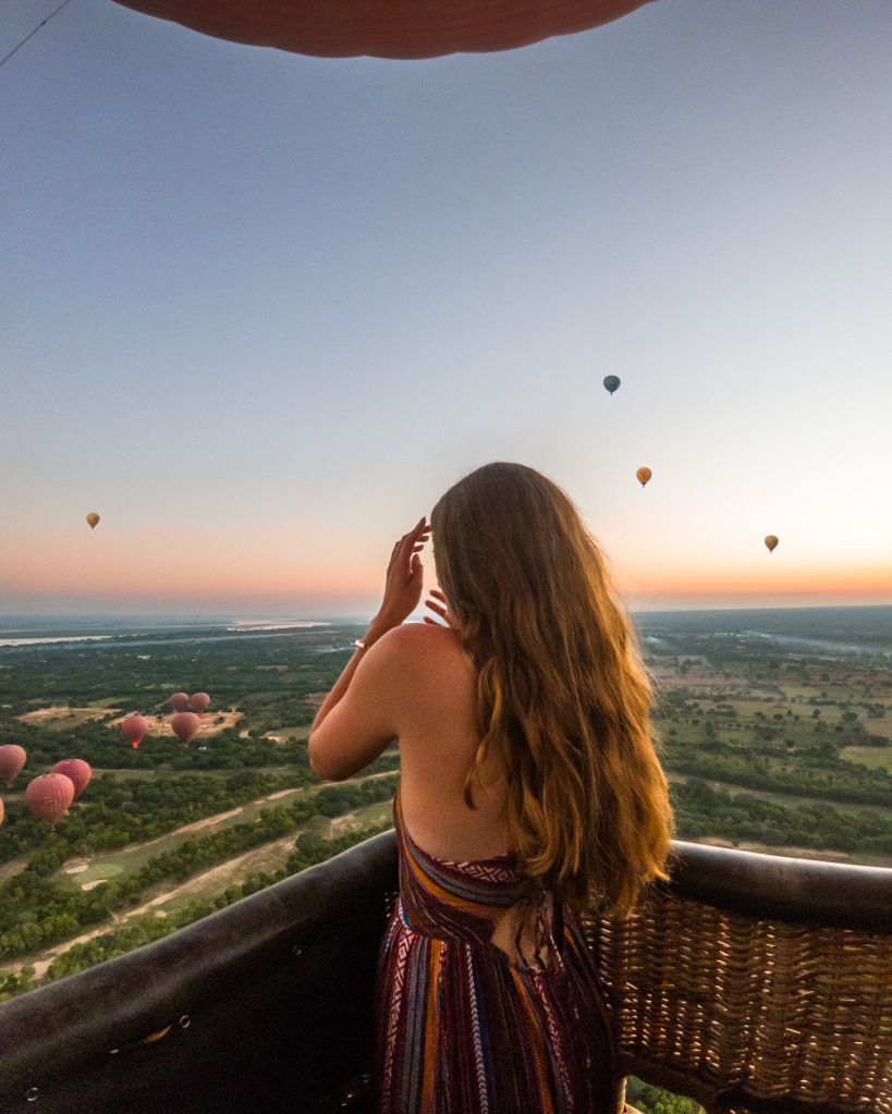 Woman in hot air ballon watching  sunrise 